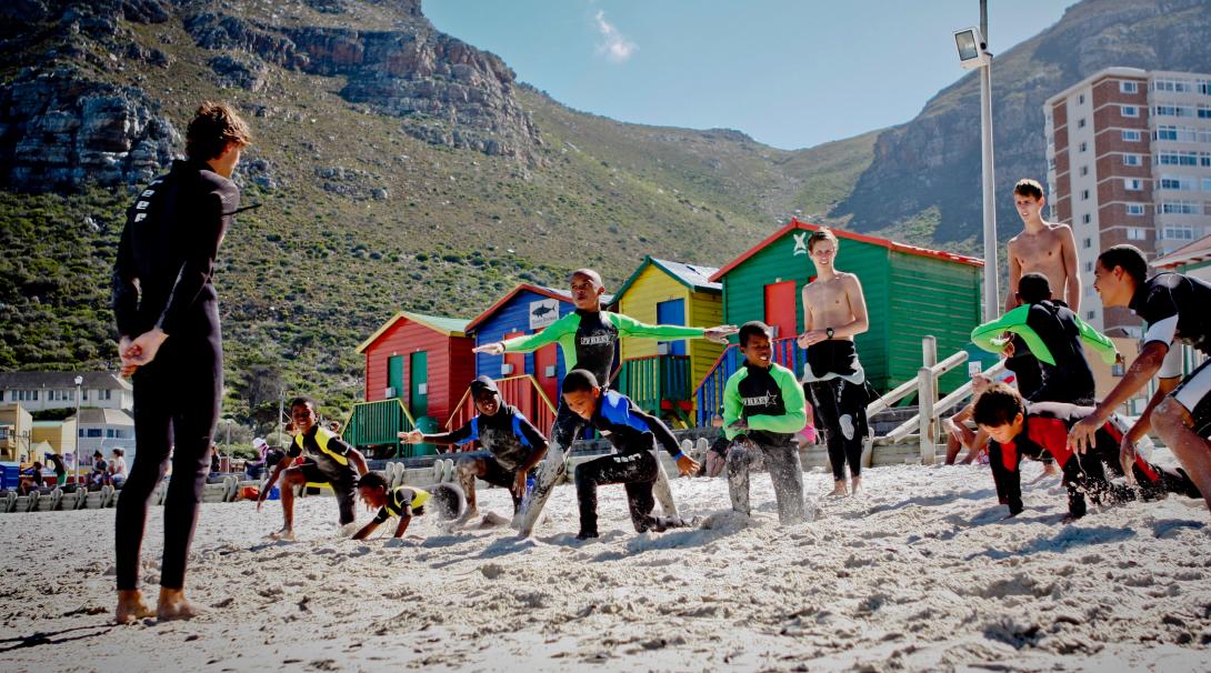 Volunteer getting children ready for surfing in South Africa Stretching on the beach in a surfing project, South Africa